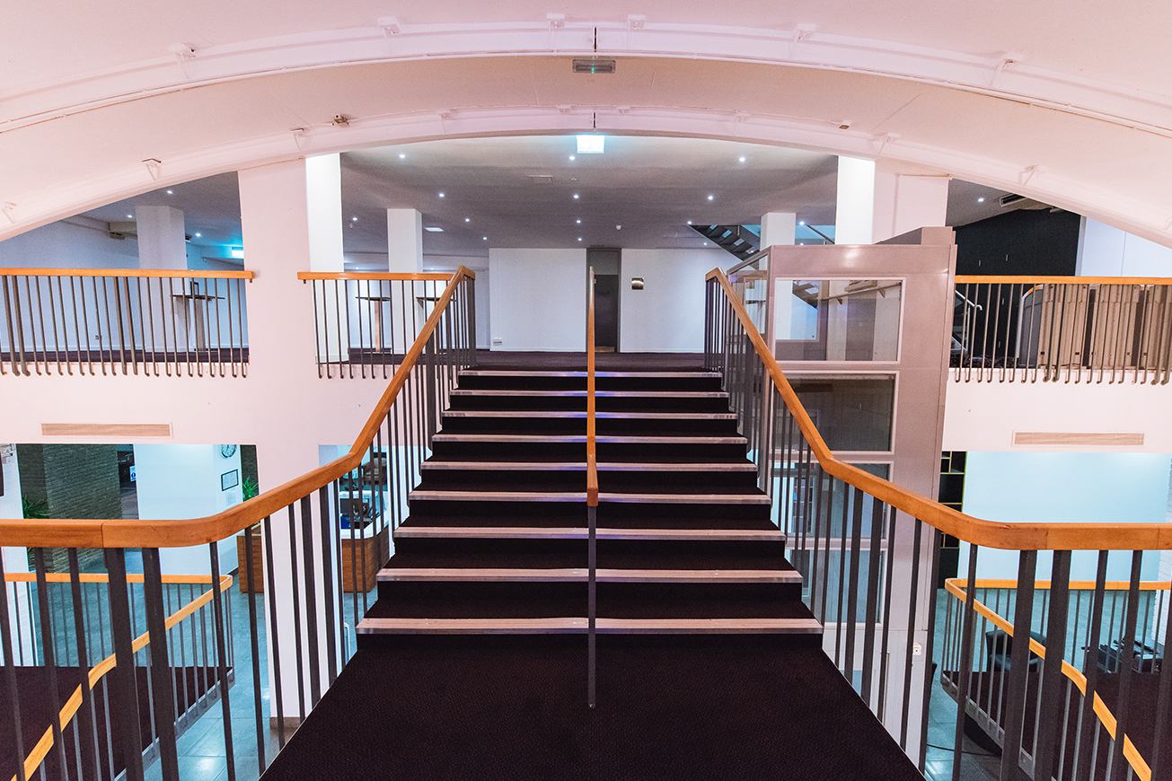 a staircase with a black carpet and wooden railings