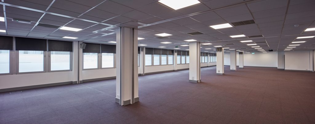 Newgate 3 a large empty room with white pillars and windows