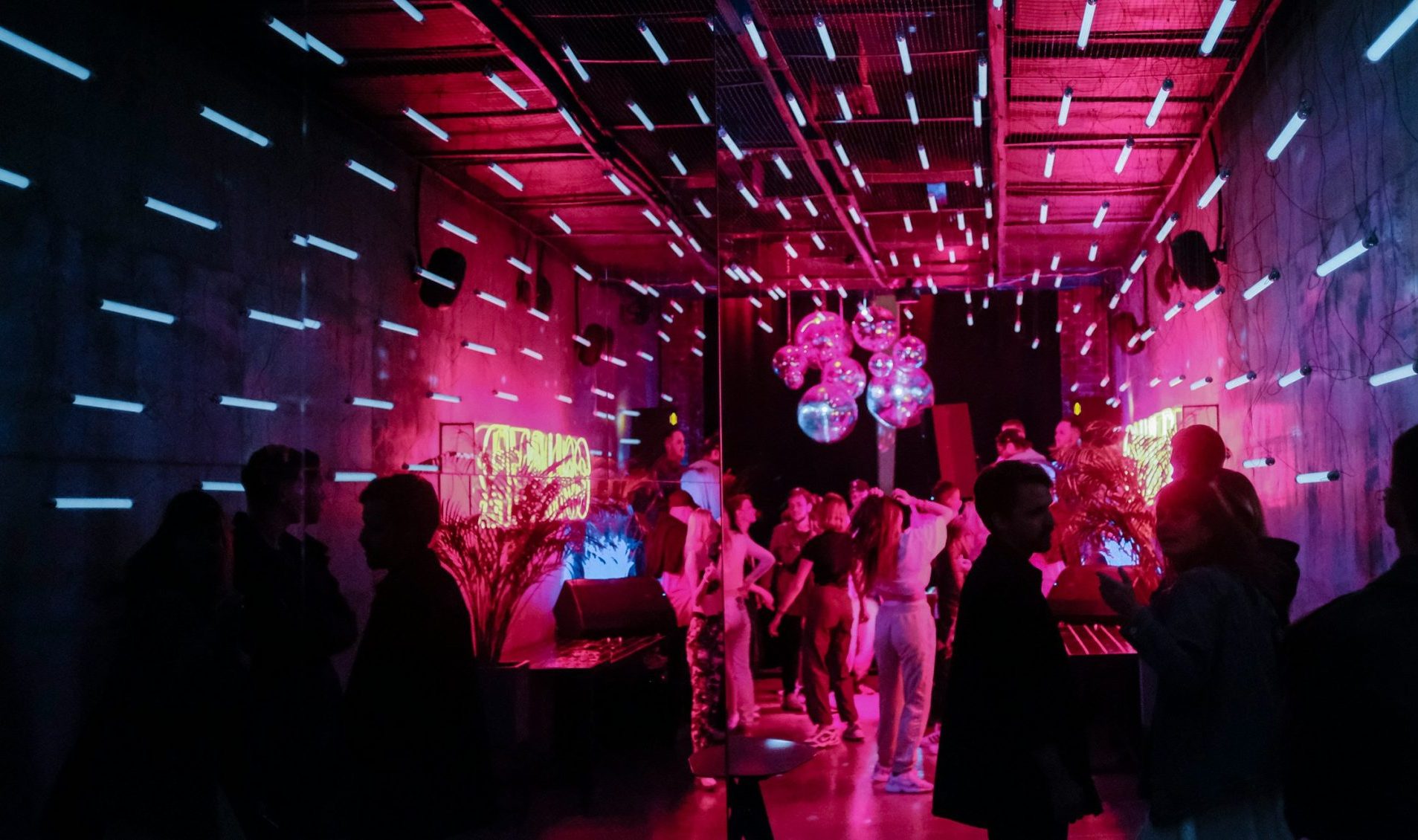Social Events 3 a group of people in a room with pink lights